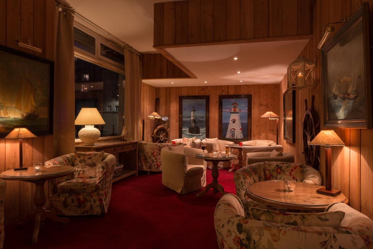 un hall d'hôtel avec des canapés, des tables et des chaises dans l'établissement Hôtel Spa Vent d'Ouest, au Havre
