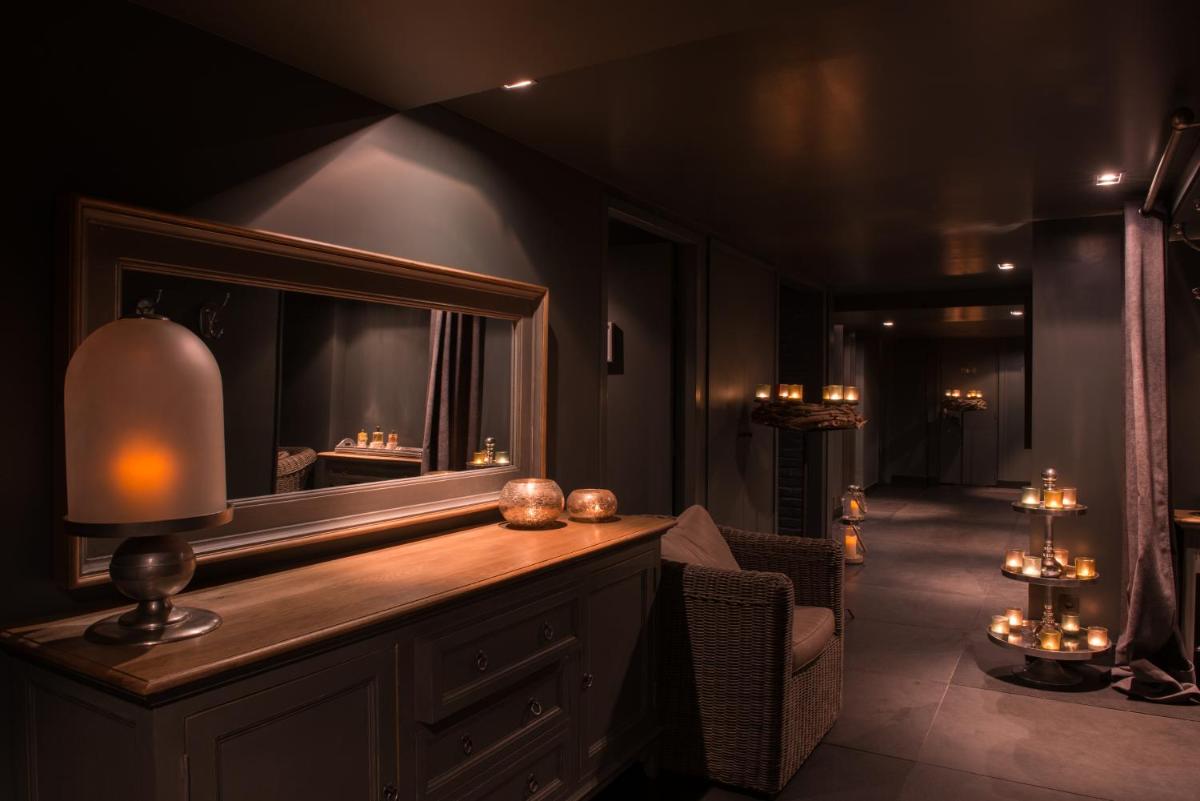 une pièce avec une table avec un miroir et une lampe dans l'établissement Hôtel Spa Vent d'Ouest, au Havre