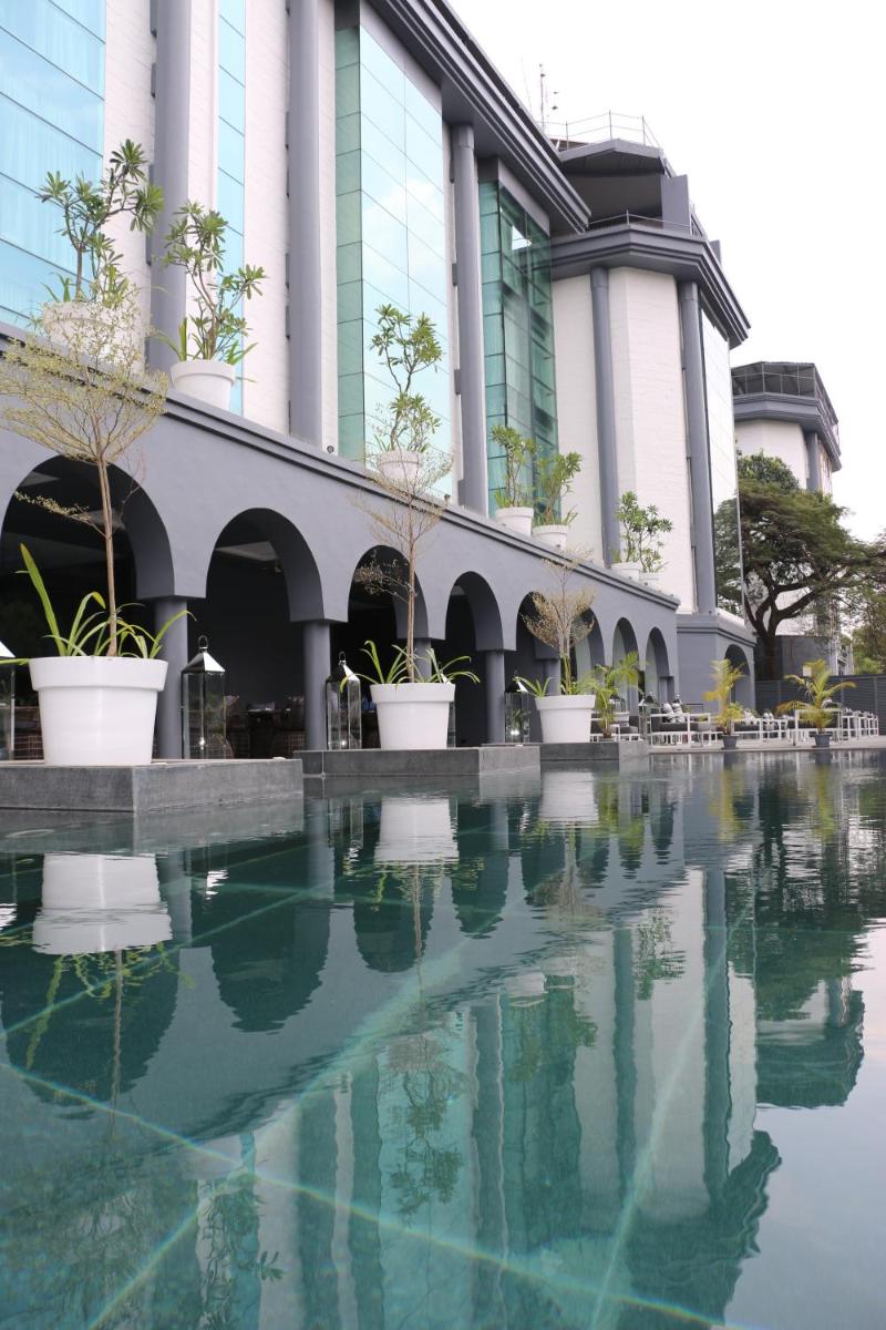 a building with a pool of water in front of it at Radisson Blu Atria Bengaluru in Bengaluru a building with a pool of water in front of it at Radisson Blu Atria Bengaluru in Bengaluru
