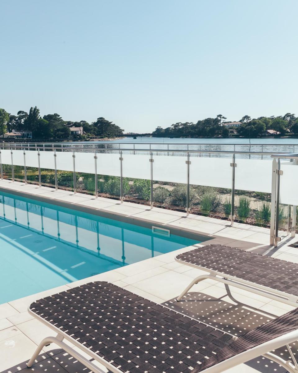 une piscine avec vue sur l'eau dans l'établissement Hôtel & Spa Villa Seren, à Hossegor