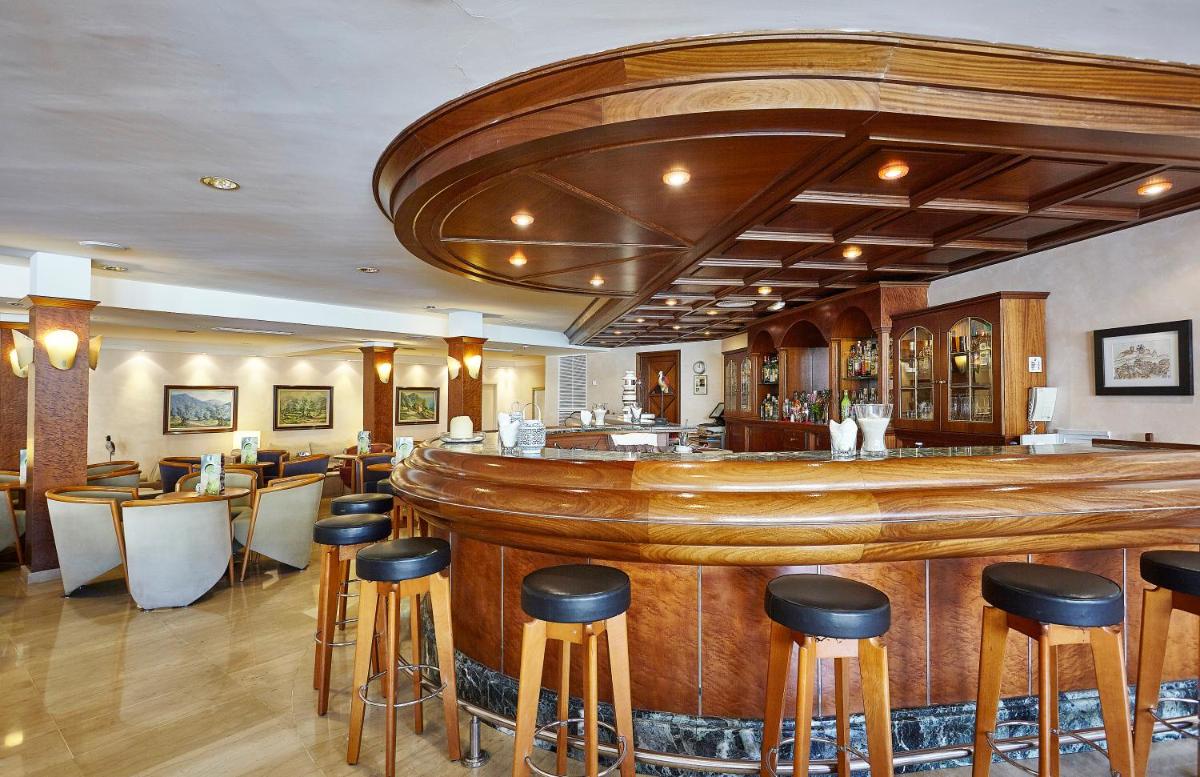 una barra en un restaurante con taburetes en Grupotel Nilo & Spa, en Paguera