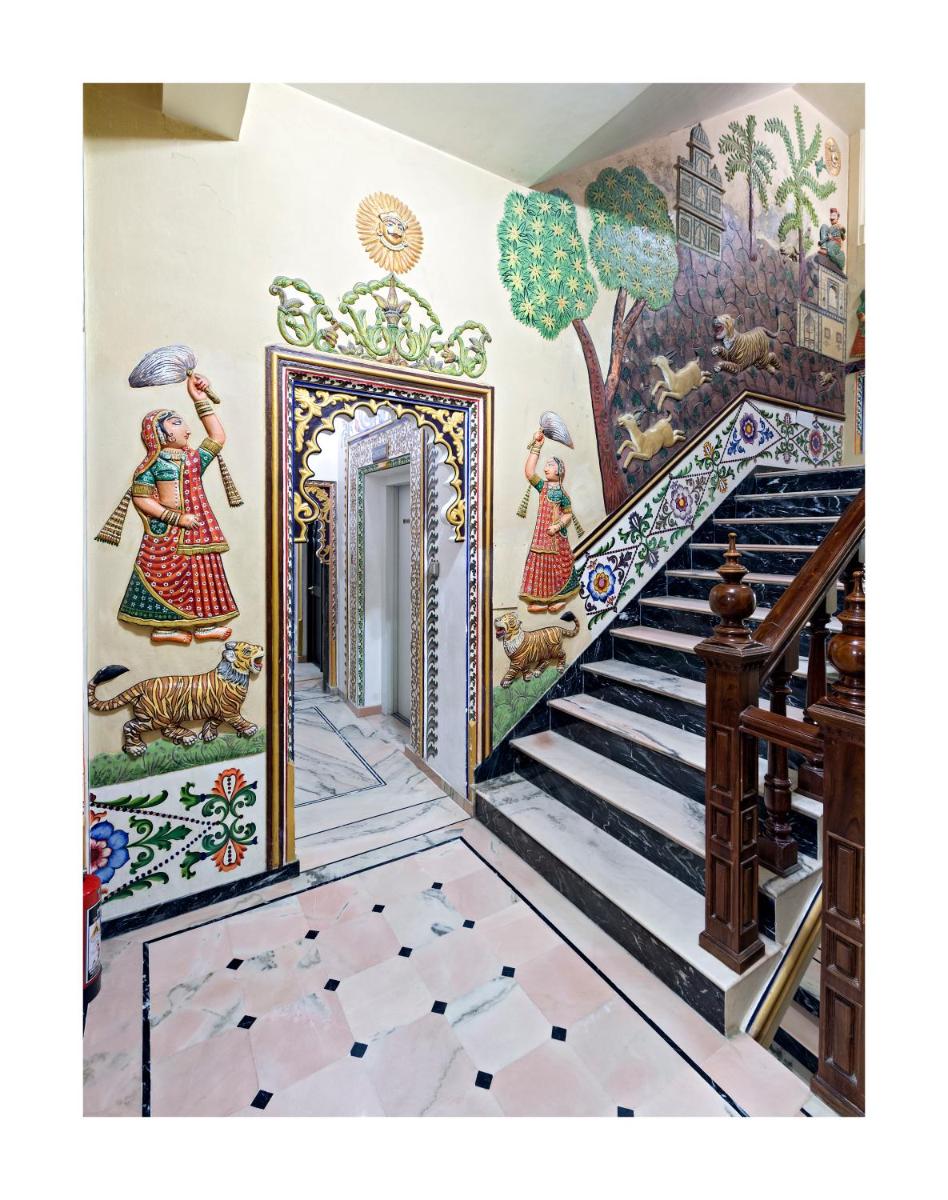 a room with a staircase with a painting on the wall at Chunda Palace in Udaipur