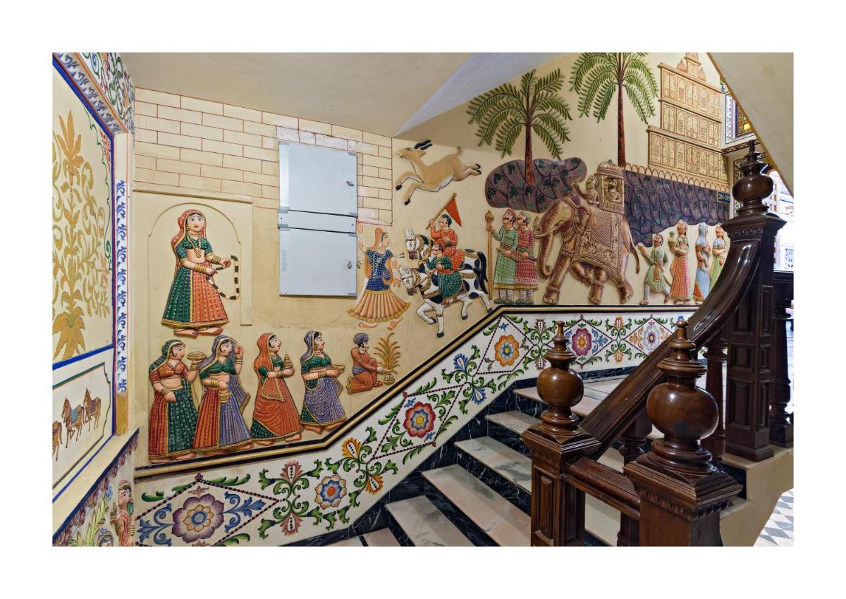 a staircase with a mural on the wall at Chunda Palace in Udaipur