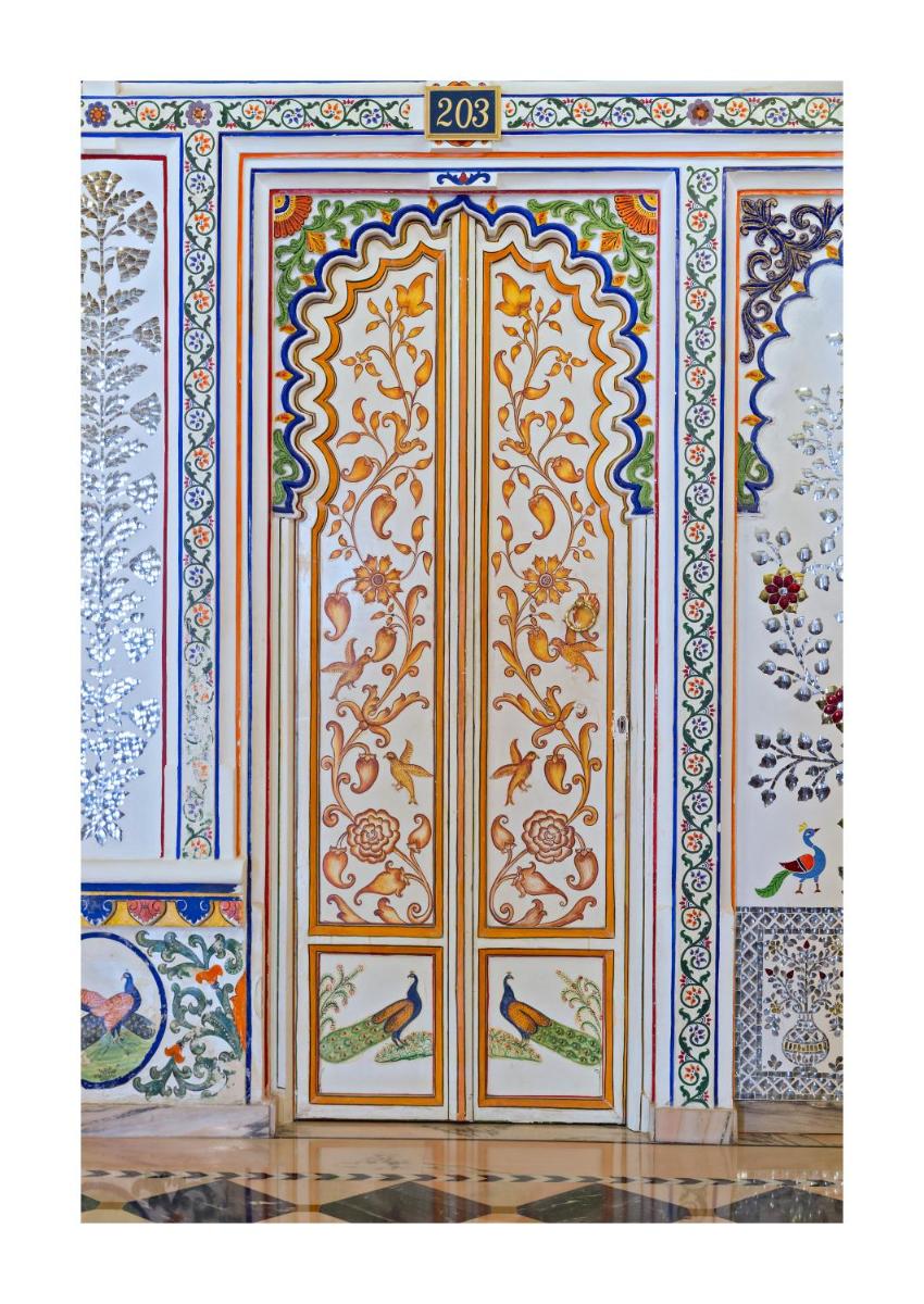 a room with a large door with paintings on it at Chunda Palace in Udaipur