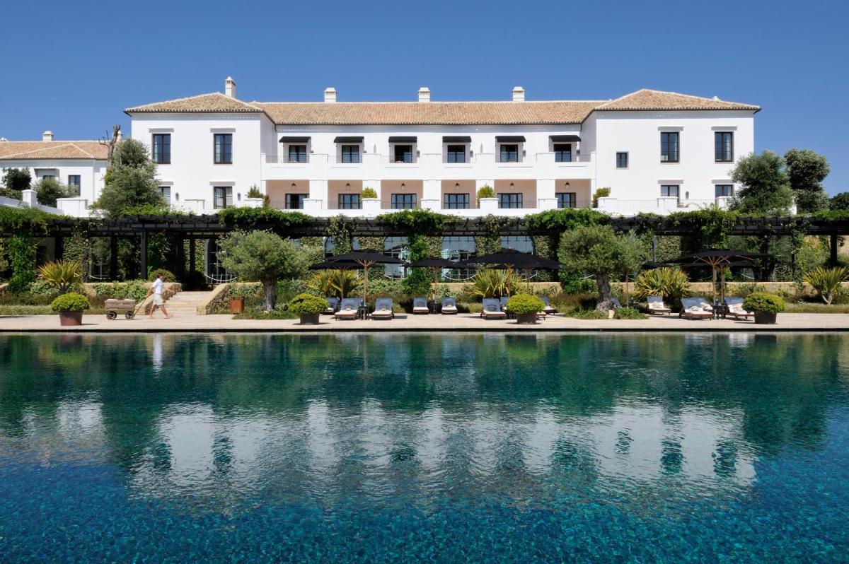 Un edificio con un estanque de agua enfrente. en Finca Cortesin Hotel Golf & Spa, en Casares