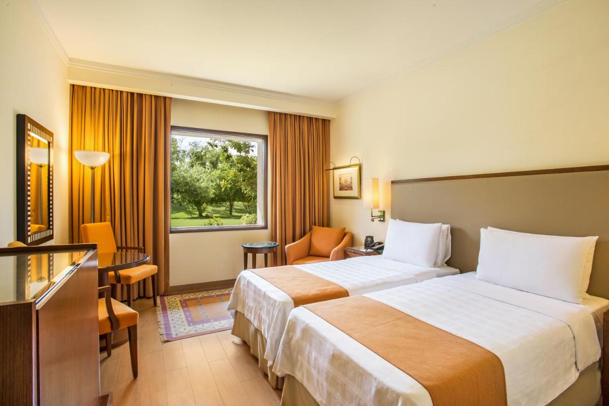 a hotel room with two beds and a window at Trident Agra in Agra