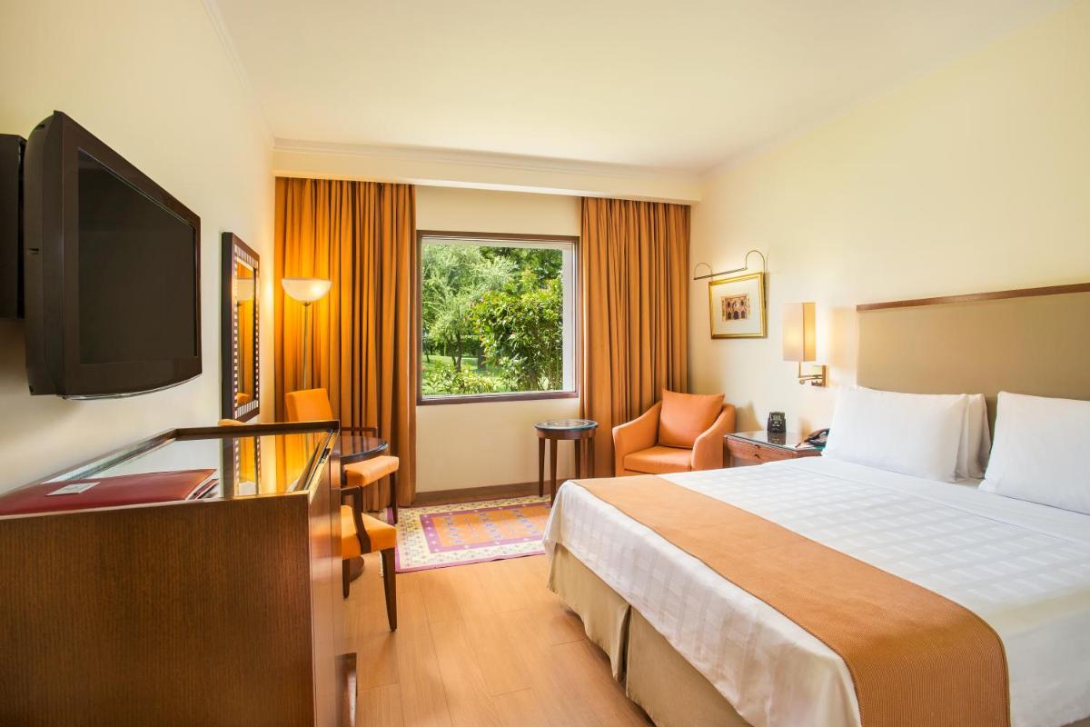 a hotel room with a bed and a flat screen tv at Trident Agra in Agra