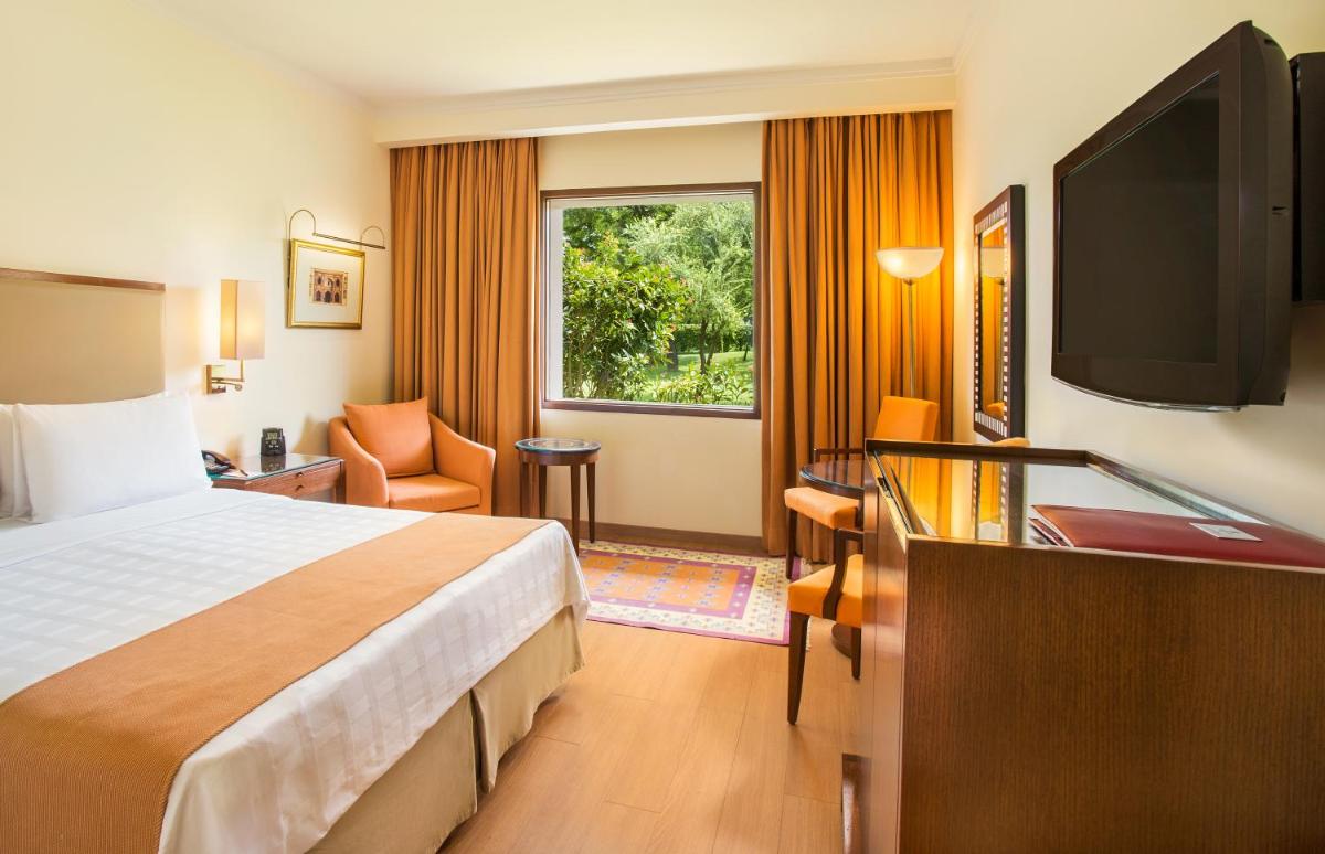 a hotel room with a bed and a flat screen tv at Trident Agra in Agra