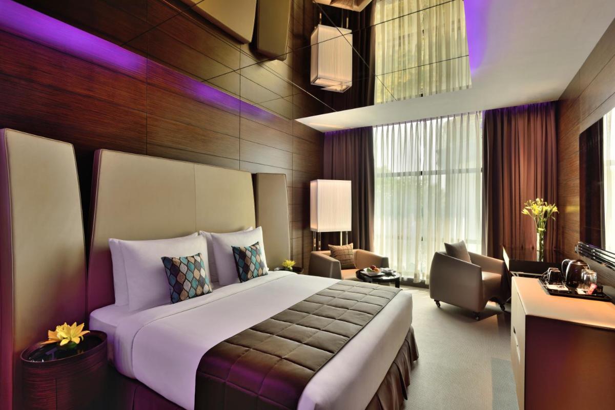 a bedroom with a large bed and a living room at Radisson Blu Atria Bengaluru in Bengaluru a bedroom with a large bed and a living room at Radisson Blu Atria Bengaluru in Bengaluru