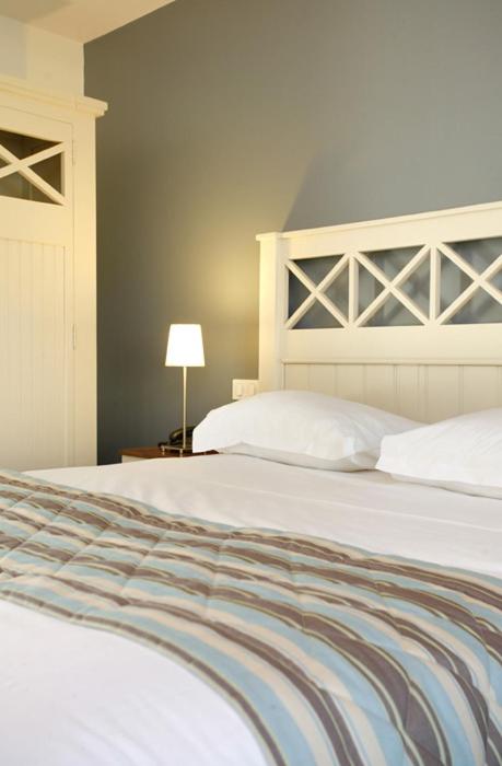 Un ou plusieurs lits dans un hébergement de l'établissement Logis Hotel, restaurant et spa Le Relais De Broceliande