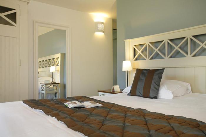 Un ou plusieurs lits dans un hébergement de l'établissement Logis Hotel, restaurant et spa Le Relais De Broceliande