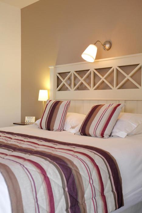 Un ou plusieurs lits dans un hébergement de l'établissement Logis Hotel, restaurant et spa Le Relais De Broceliande