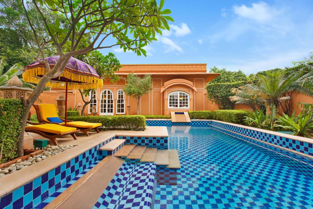 a swimming pool in front of a house at The Oberoi Rajvilas Jaipur in Jaipur