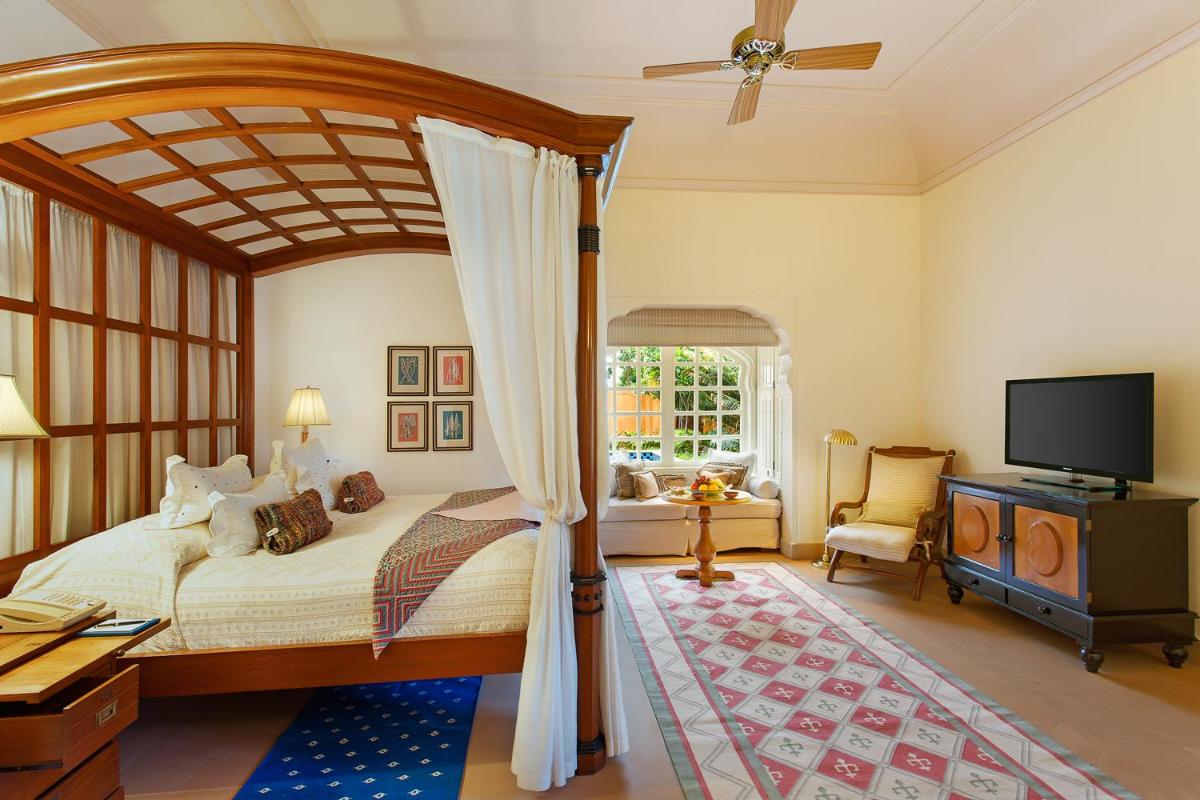 a bedroom with a canopy bed and a flat screen tv at The Oberoi Rajvilas Jaipur in Jaipur