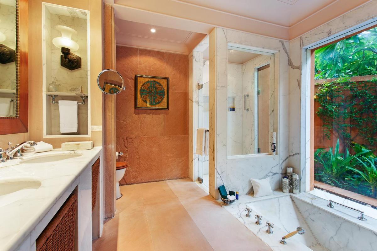a bathroom with a tub and a shower and a sink at The Oberoi Rajvilas Jaipur in Jaipur