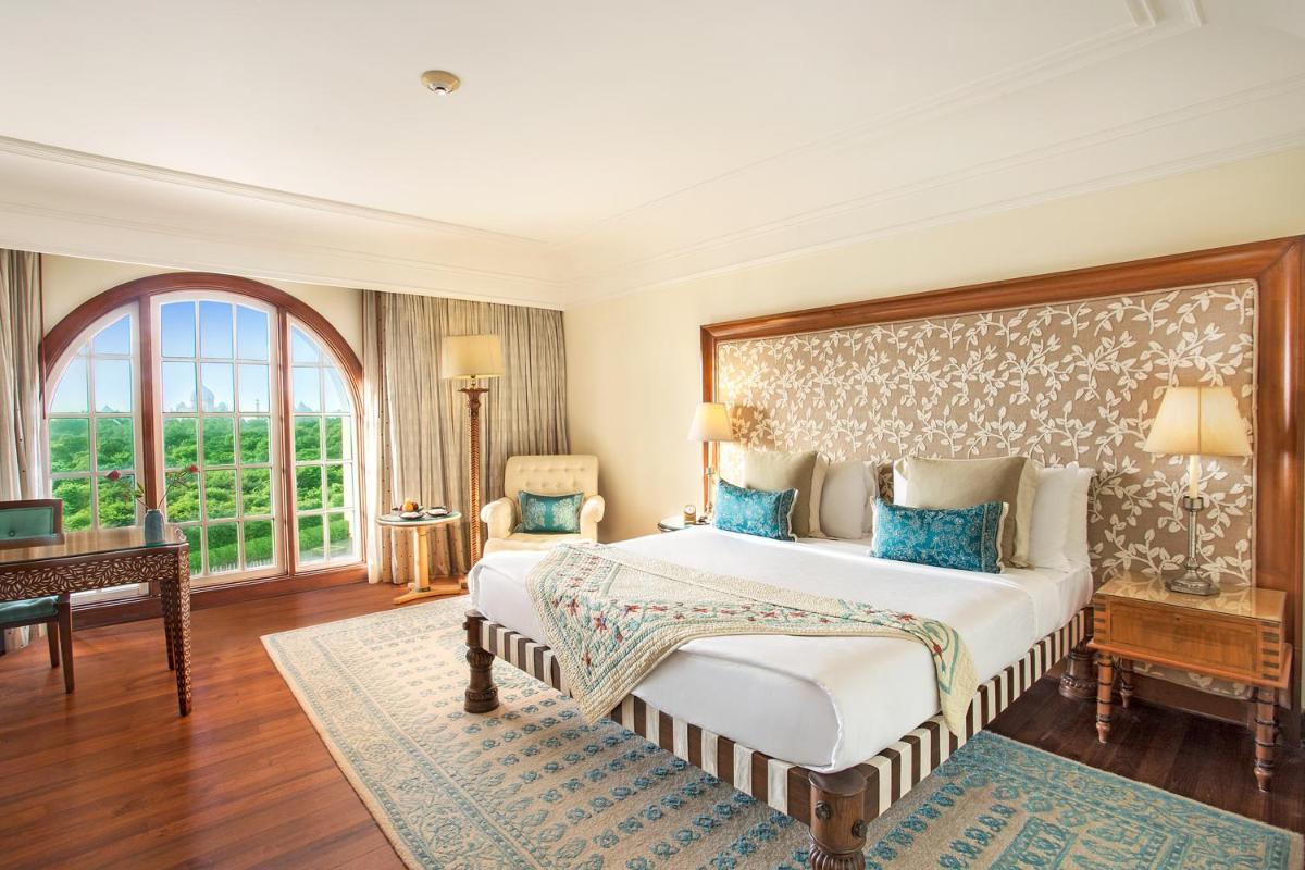 a bedroom with a large bed and a desk at The Oberoi Amarvilas Agra in Agra