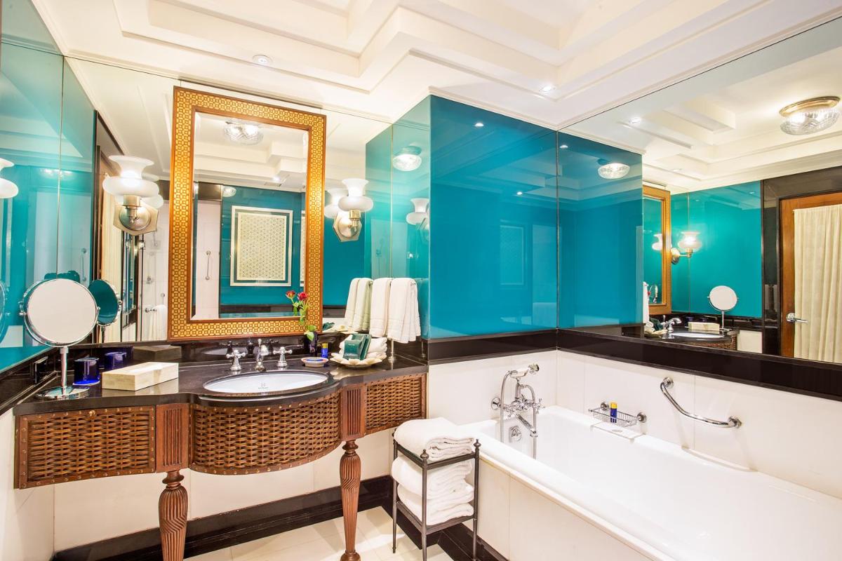 a bathroom with blue walls and a tub and a sink at The Oberoi Amarvilas Agra in Agra