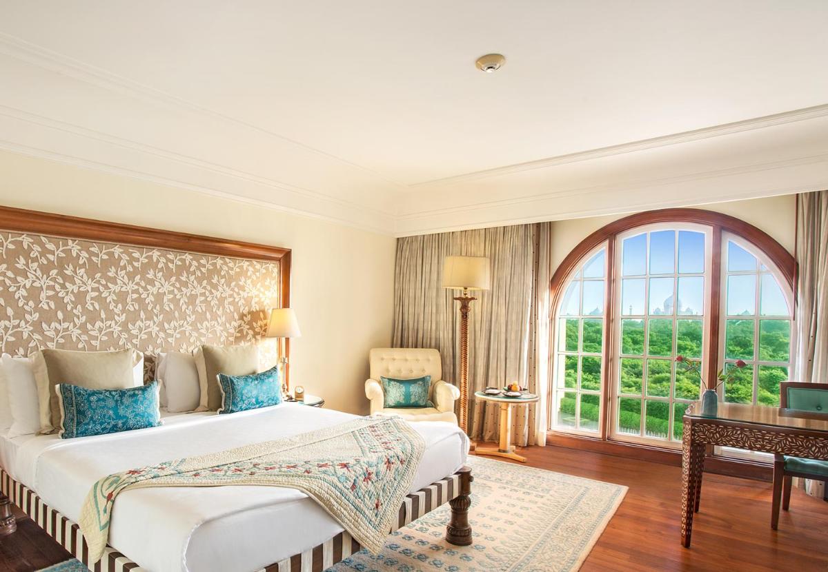 a bedroom with a bed and a large window at The Oberoi Amarvilas Agra in Agra