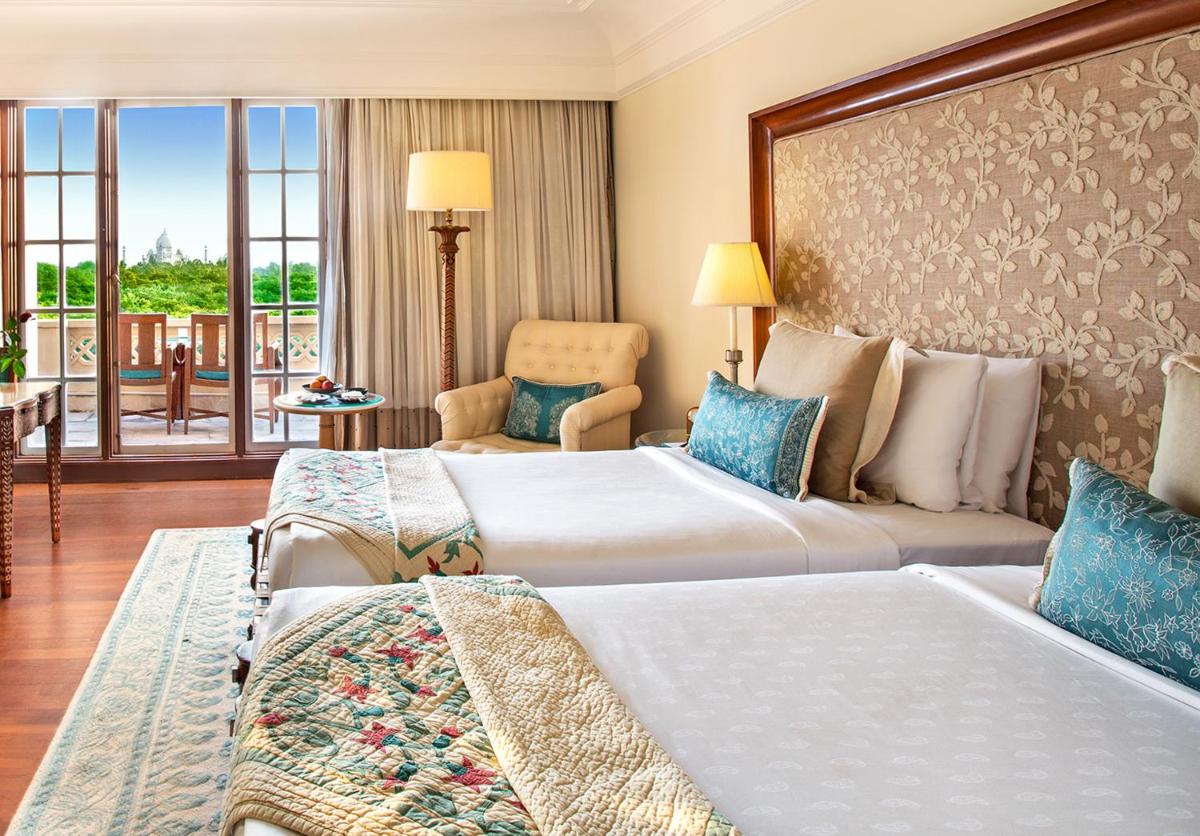 a hotel room with two beds and a balcony at The Oberoi Amarvilas Agra in Agra