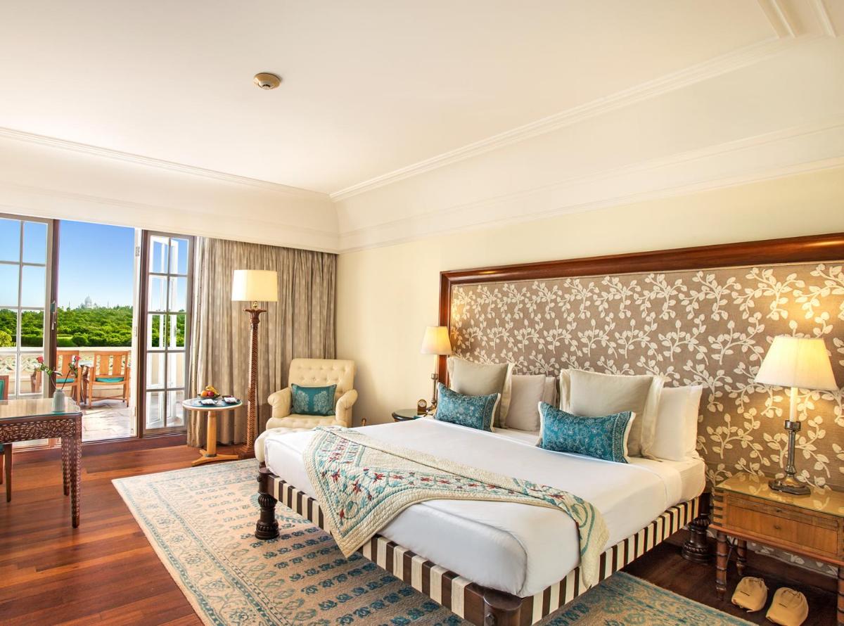 a bedroom with a large bed and a balcony at The Oberoi Amarvilas Agra in Agra