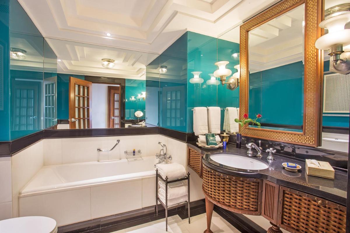 a bathroom with a tub and a large mirror at The Oberoi Amarvilas Agra in Agra