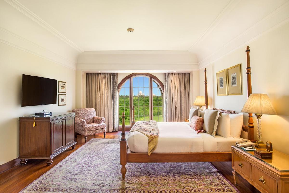 a bedroom with a bed and a large window at The Oberoi Amarvilas Agra in Agra