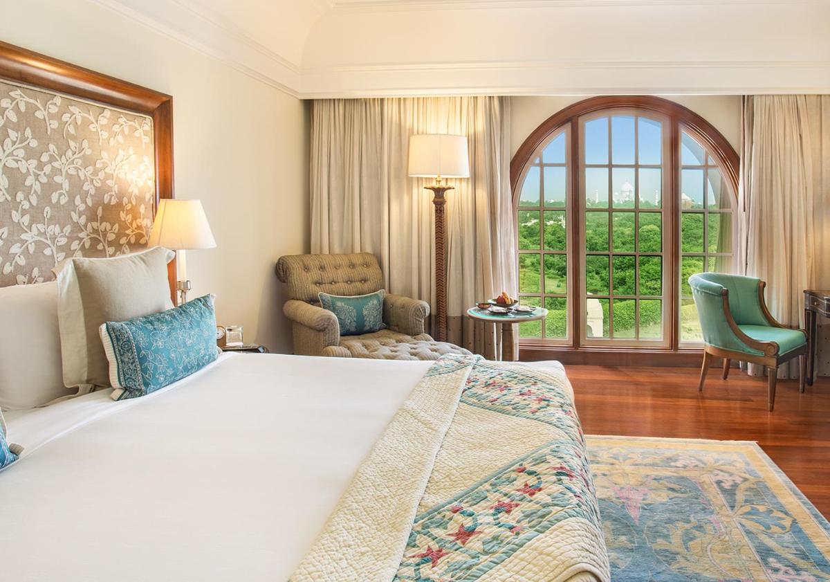 a bedroom with a large bed and a large window at The Oberoi Amarvilas Agra in Agra