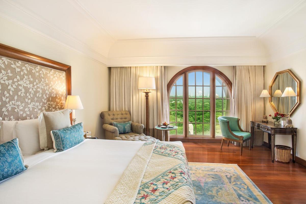a bedroom with a large bed and a desk at The Oberoi Amarvilas Agra in Agra