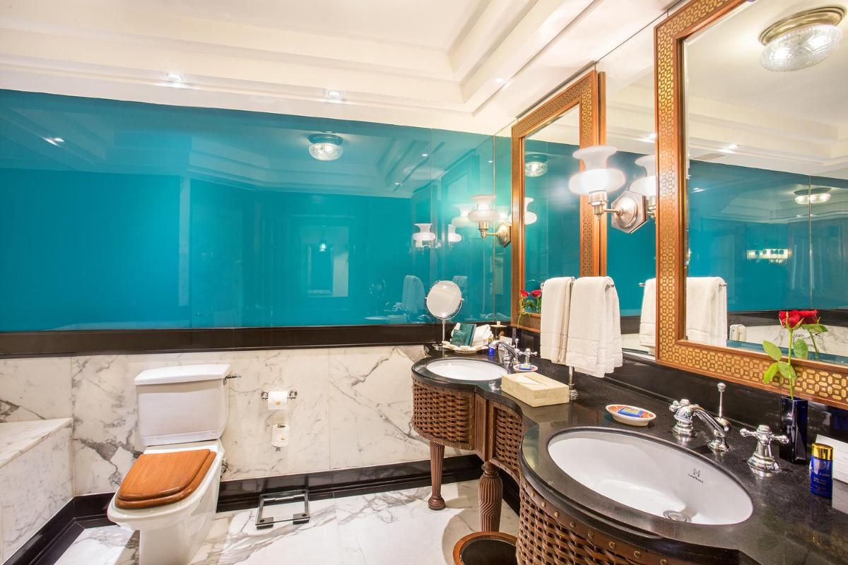 a bathroom with two sinks and a toilet and a mirror at The Oberoi Amarvilas Agra in Agra