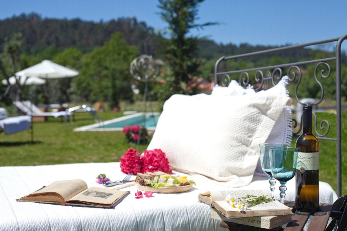 uma mesa de piquenique com uma garrafa de vinho e um prato de comida em Carmo's Boutique Hotel - Small Luxury Hotels of the World em Ponte de Lima