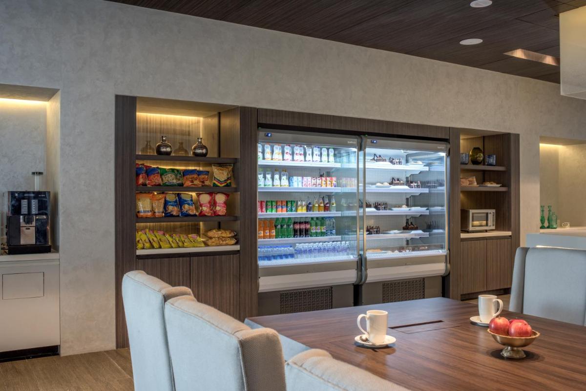a dining room with a table and a refrigerator at The Residency Towers, Rameswaram in Rāmeswaram