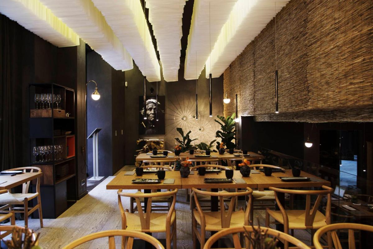 Un comedor con una mesa larga y sillas. en Axel Hotel Barcelona - Adults Only, en Barcelona