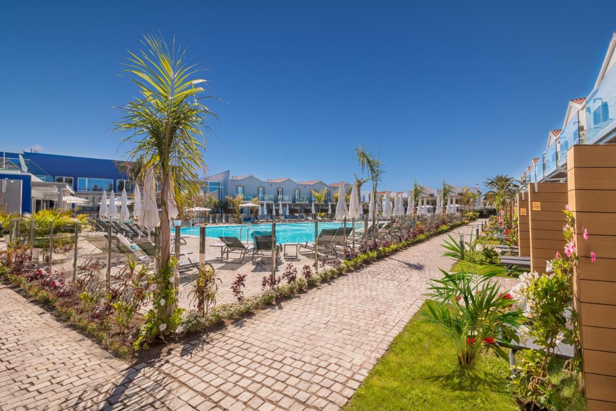 un complejo con piscina y palmeras en Hotel LIVVO Los Calderones - Adults recommended, en Maspalomas