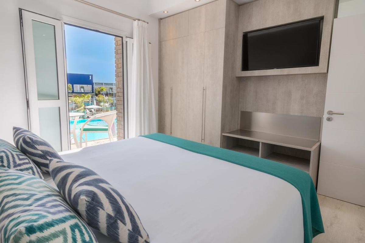 Un dormitorio con una cama y un televisor y una ventana. en Hotel LIVVO Los Calderones - Adults recommended, en Maspalomas 17 fotos más