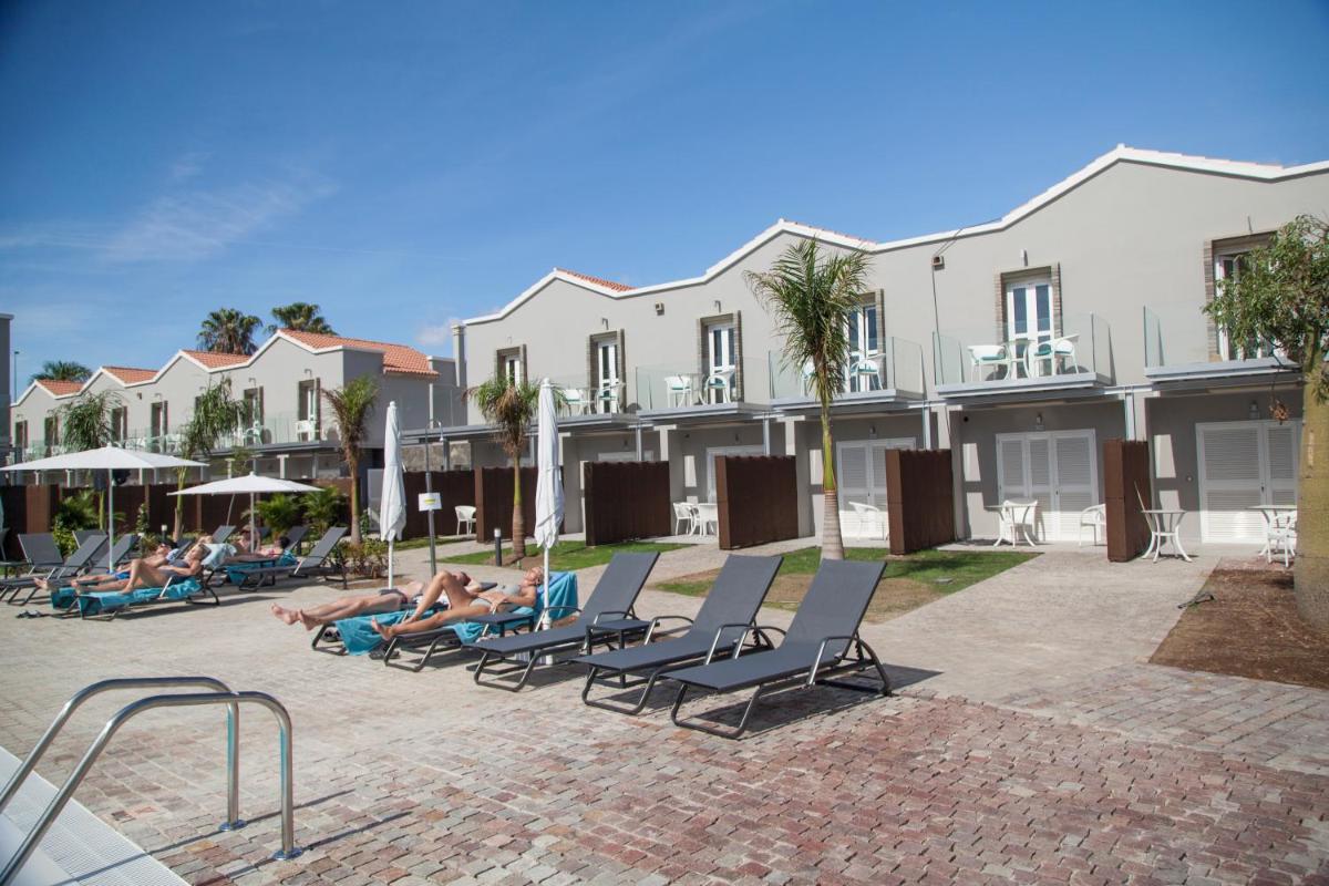 un grupo de personas sobre tumbonas en un complejo en Hotel LIVVO Los Calderones - Adults recommended, en Maspalomas