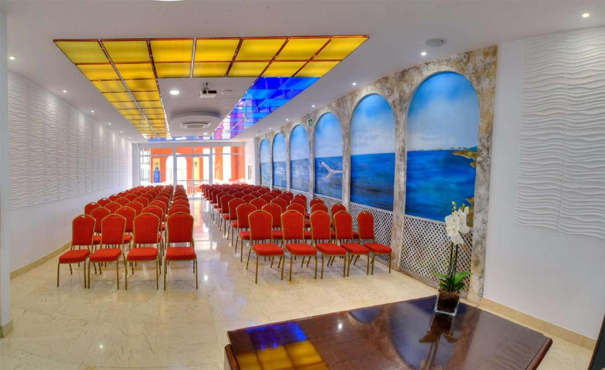 una sala de conferencias con sillas rojas y una gran pintura en Hotel & Spa Entremares, en La Manga del Mar Menor 124 fotos más