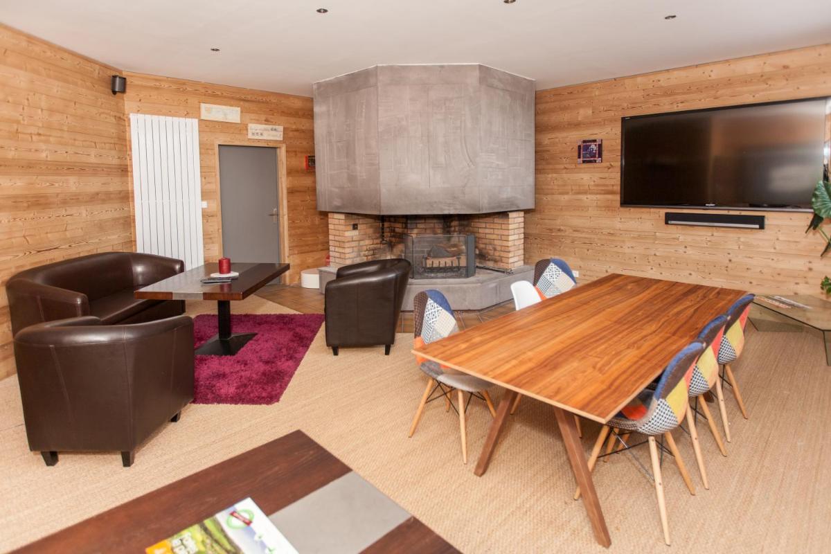 un salon avec une table et des chaises et une cheminée dans l'établissement Sancy Resort, à Chambon-sur-Lac