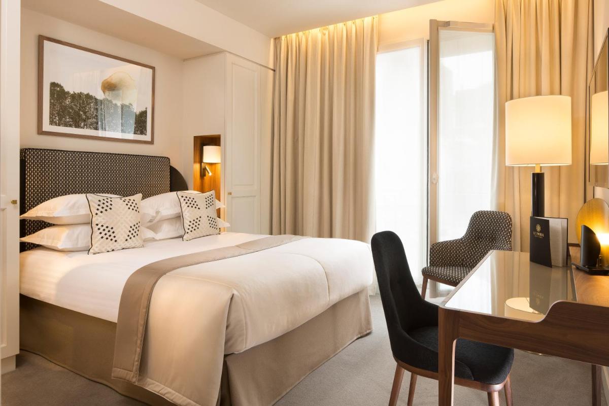 une chambre d'hôtel avec un lit et un bureau dans l'établissement Le Tsuba Hotel, à Paris
