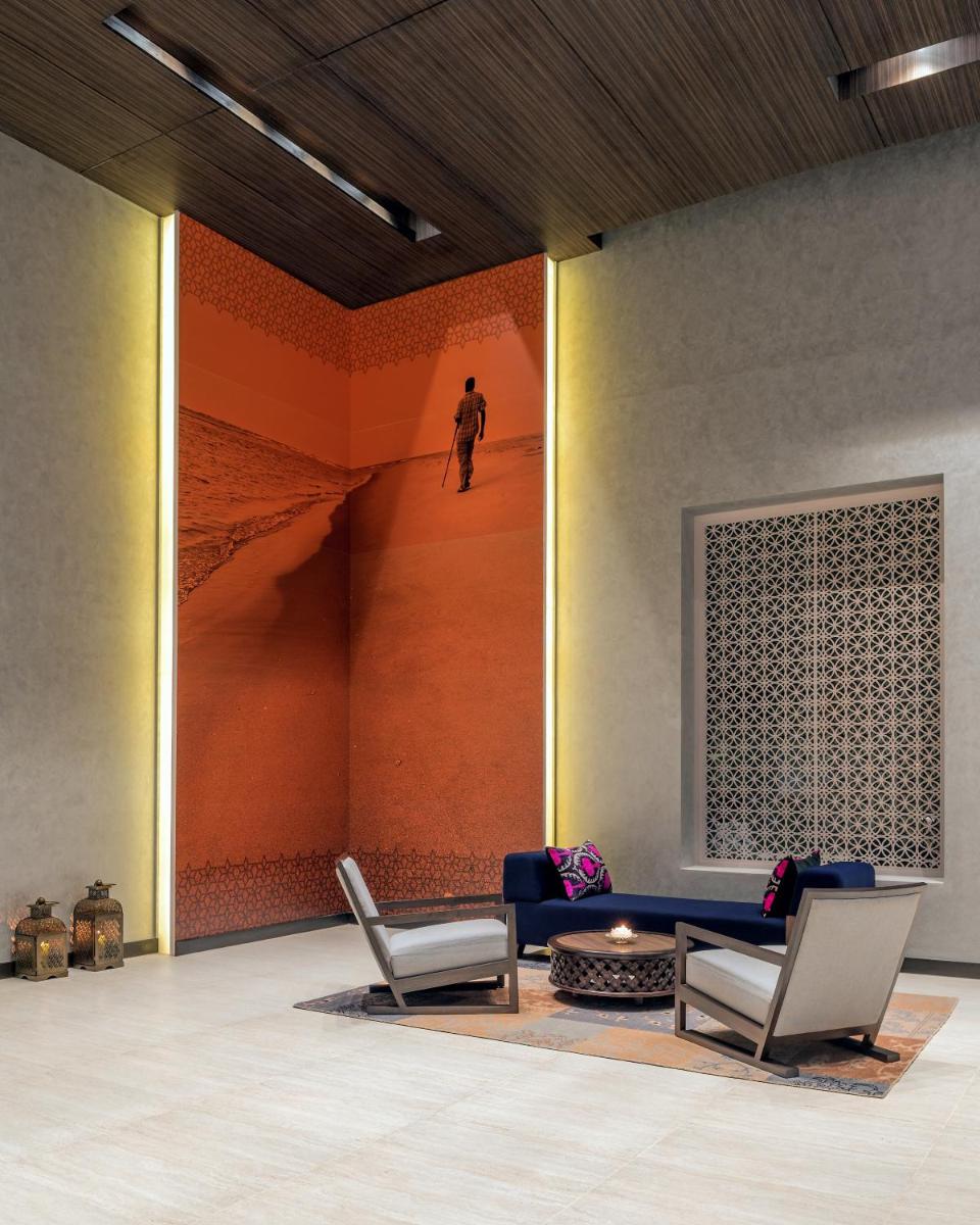 a room with two chairs and a couch and a painting at The Residency Towers, Rameswaram in Rāmeswaram