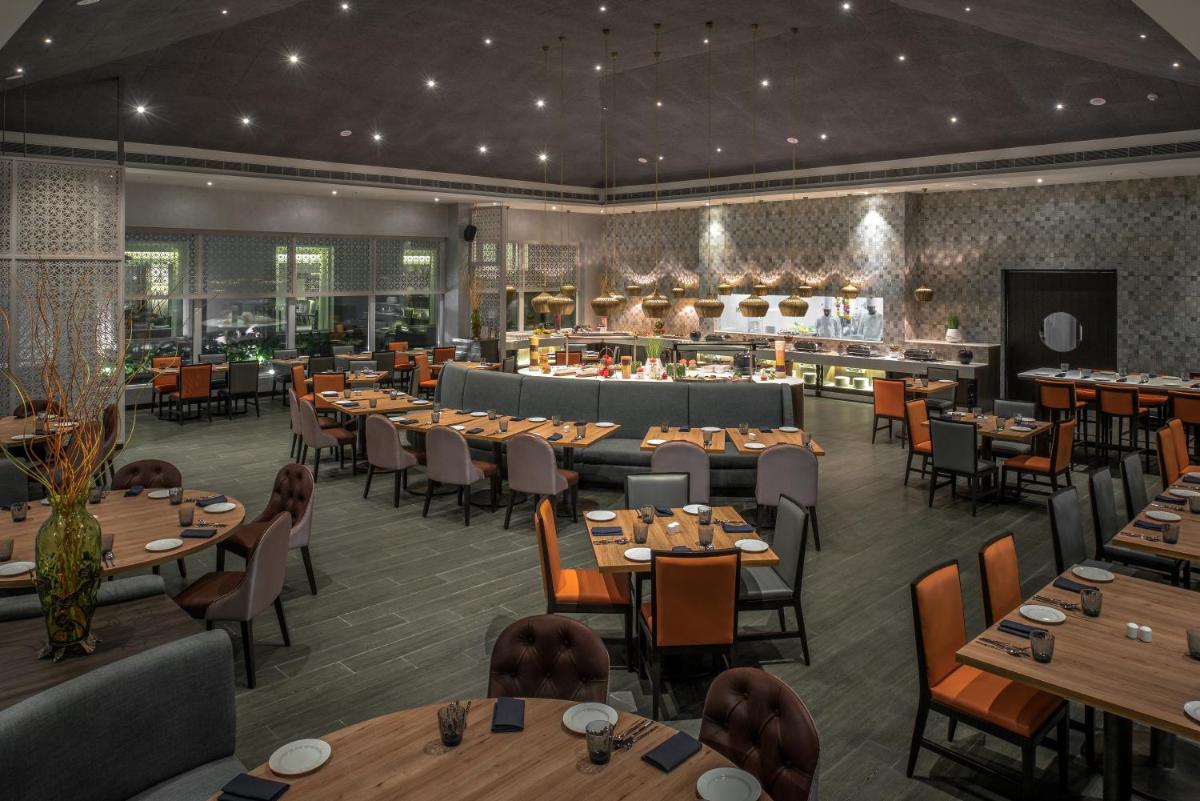 a restaurant with tables and chairs and a bar at The Residency Towers, Rameswaram in Rāmeswaram
