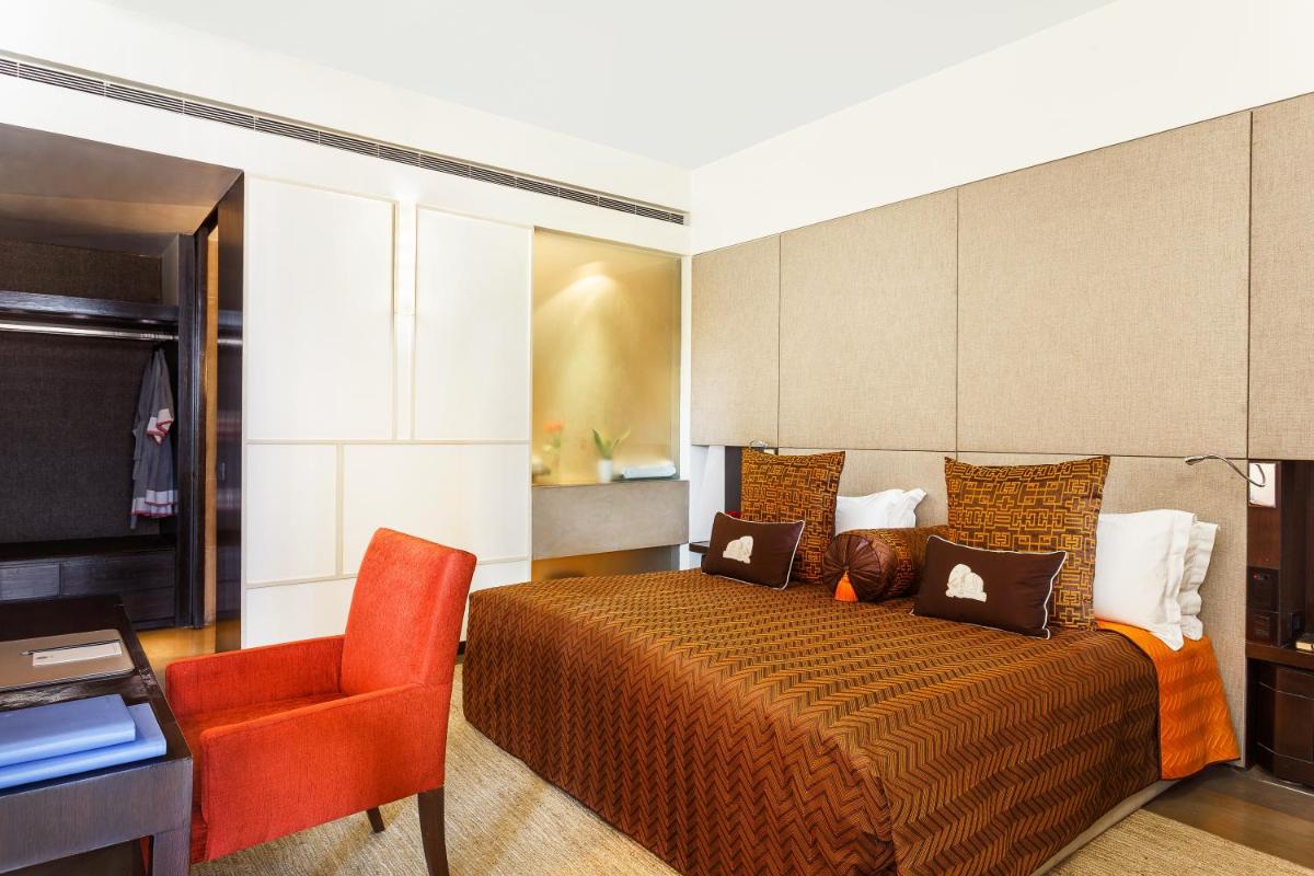 a hotel room with a bed and a chair at The Lodhi – A member of The Leading Hotels Of The World in New Delhi
