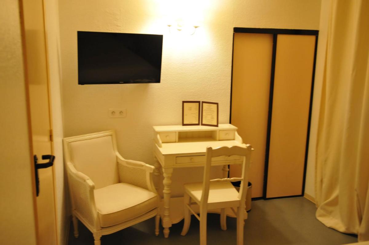 Cette chambre dispose d'un bureau, de deux chaises et d'une télévision. dans l'établissement Franceschini, à Ghisonaccia