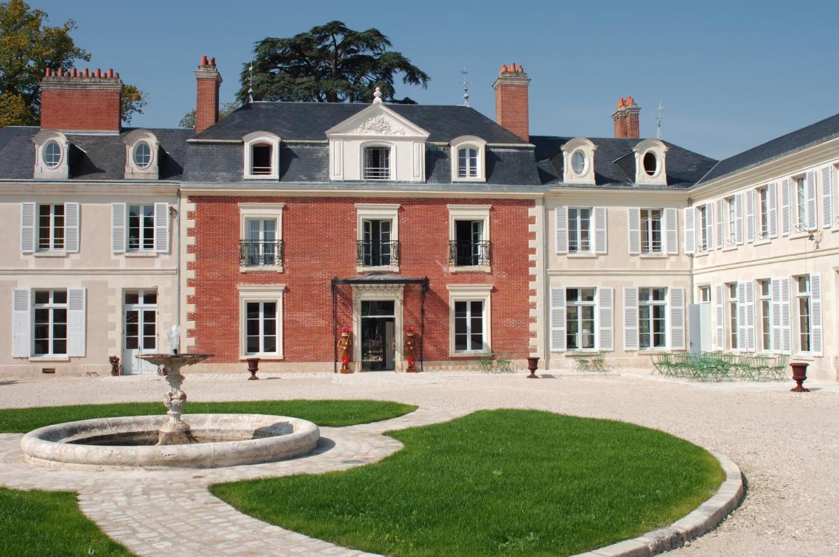 un grand bâtiment avec une fontaine devant lui dans l'établissement Hôtel & Spa du Domaine des Thômeaux, The Originals Relais, à Mosnes