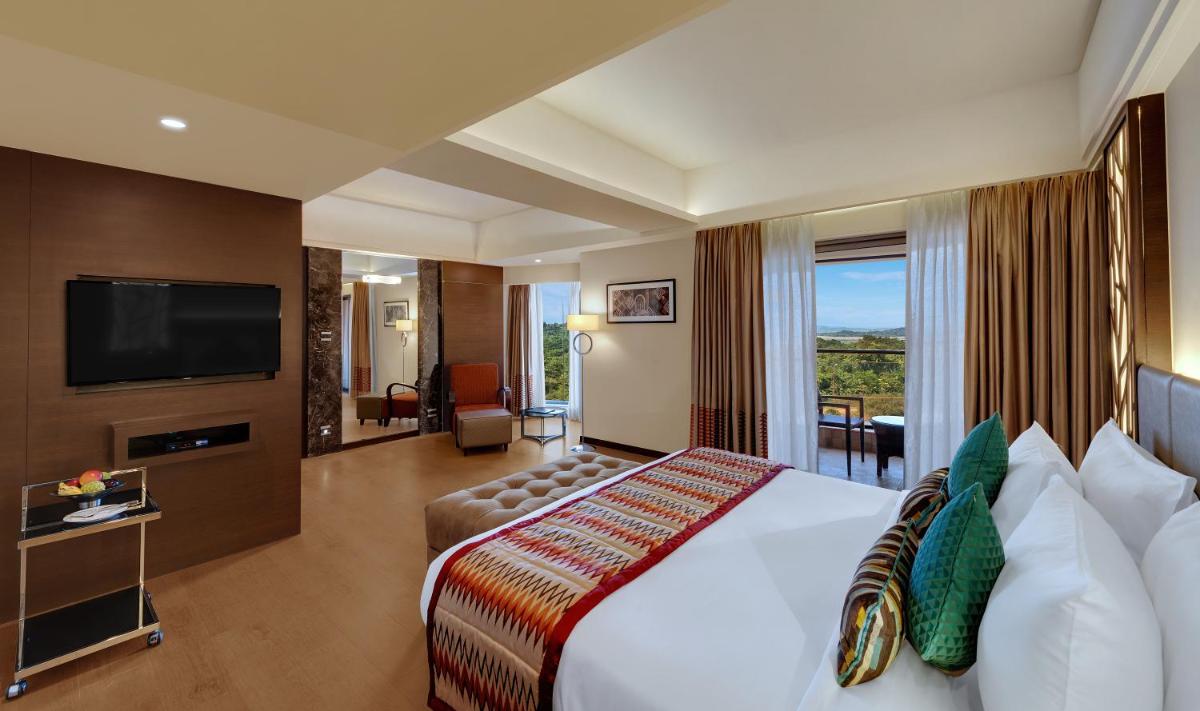 a hotel room with a bed and a television at The Fern Kadamba Hotel And Spa in Old Goa a hotel room with a bed and a television at The Fern Kadamba Hotel And Spa in Old Goa
