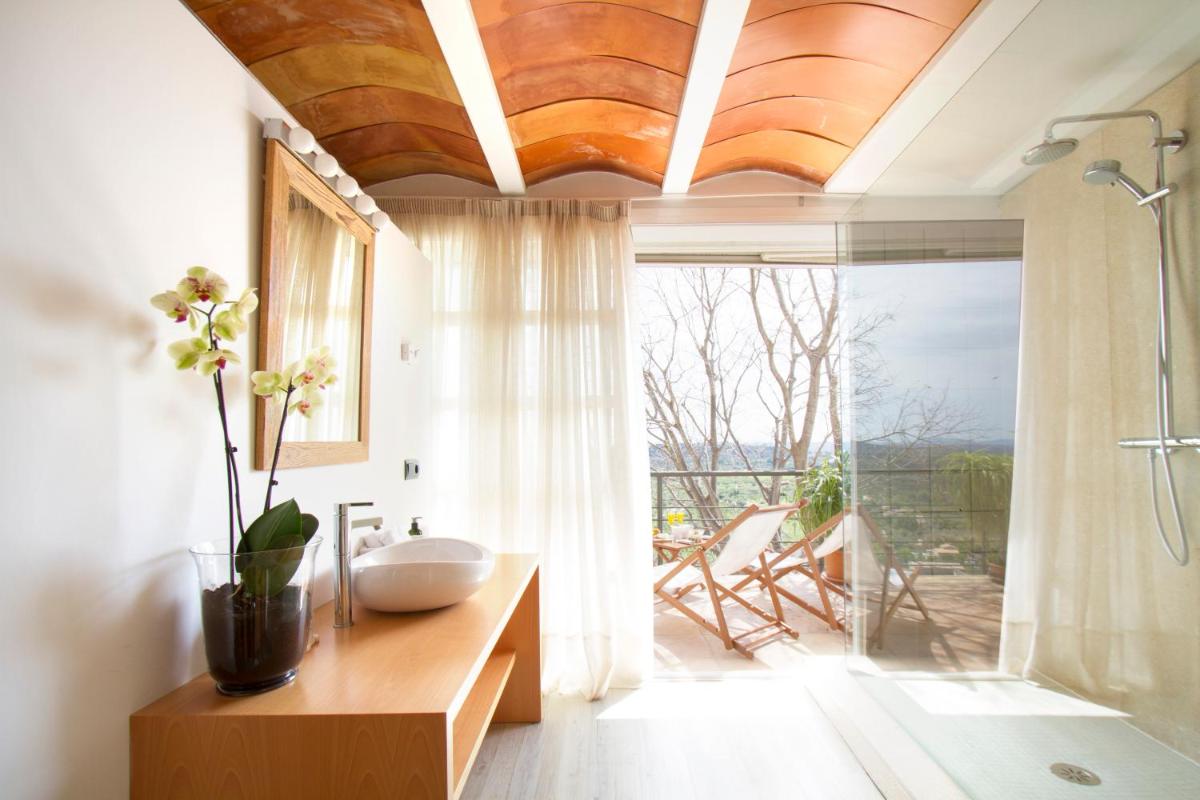 baño con lavabo y ducha con ventana en Can Cota Boutique - Turismo de interior, en Selva