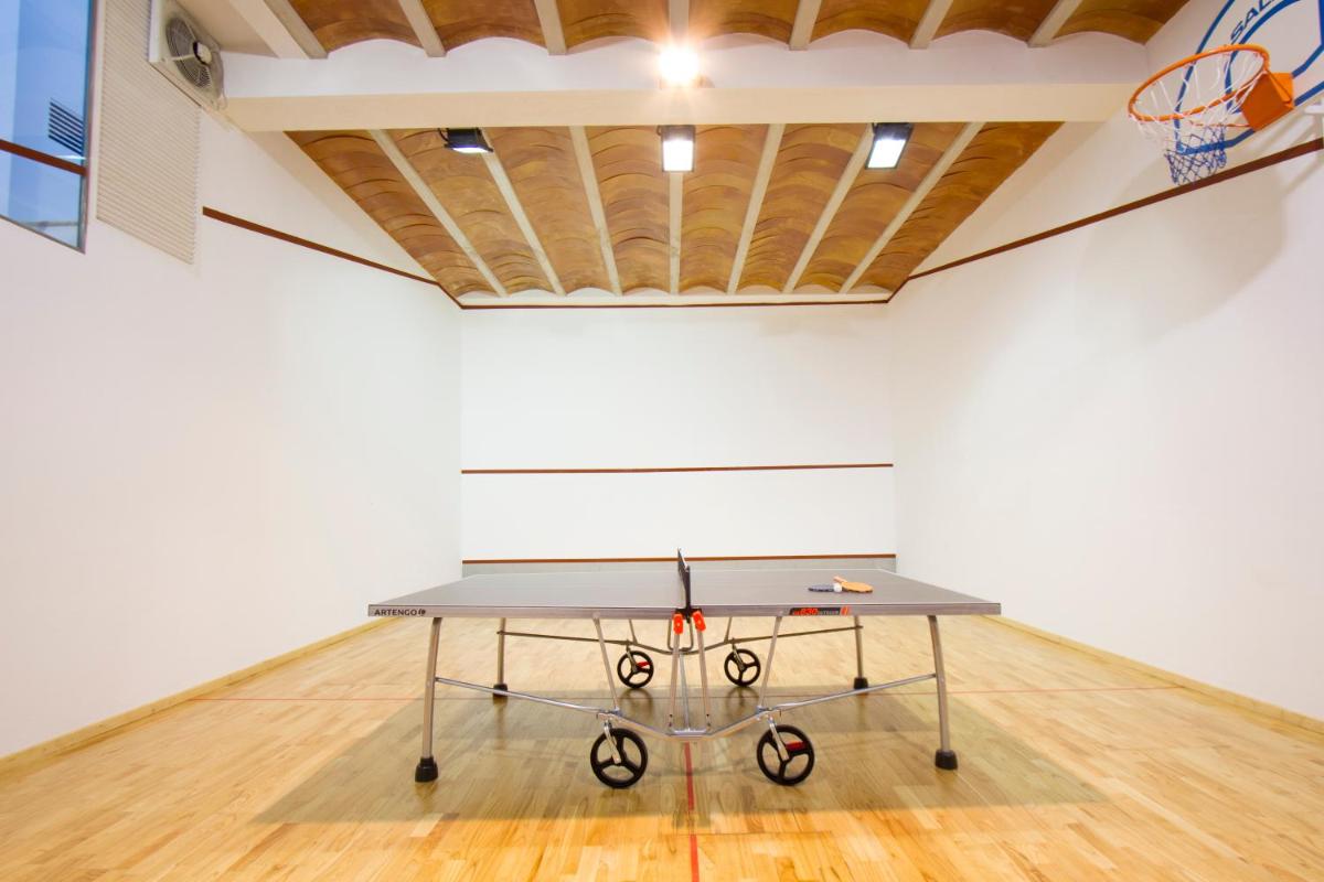 una mesa de ping pong en una habitación con un aro de baloncesto en Can Cota Boutique - Turismo de interior, en Selva