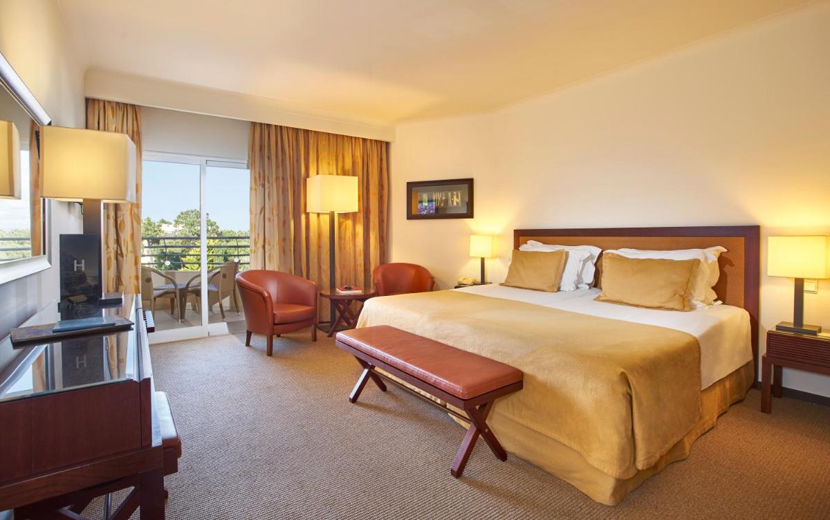 um quarto de hotel com uma cama e uma televisão em PortoBay Falesia em Albufeira