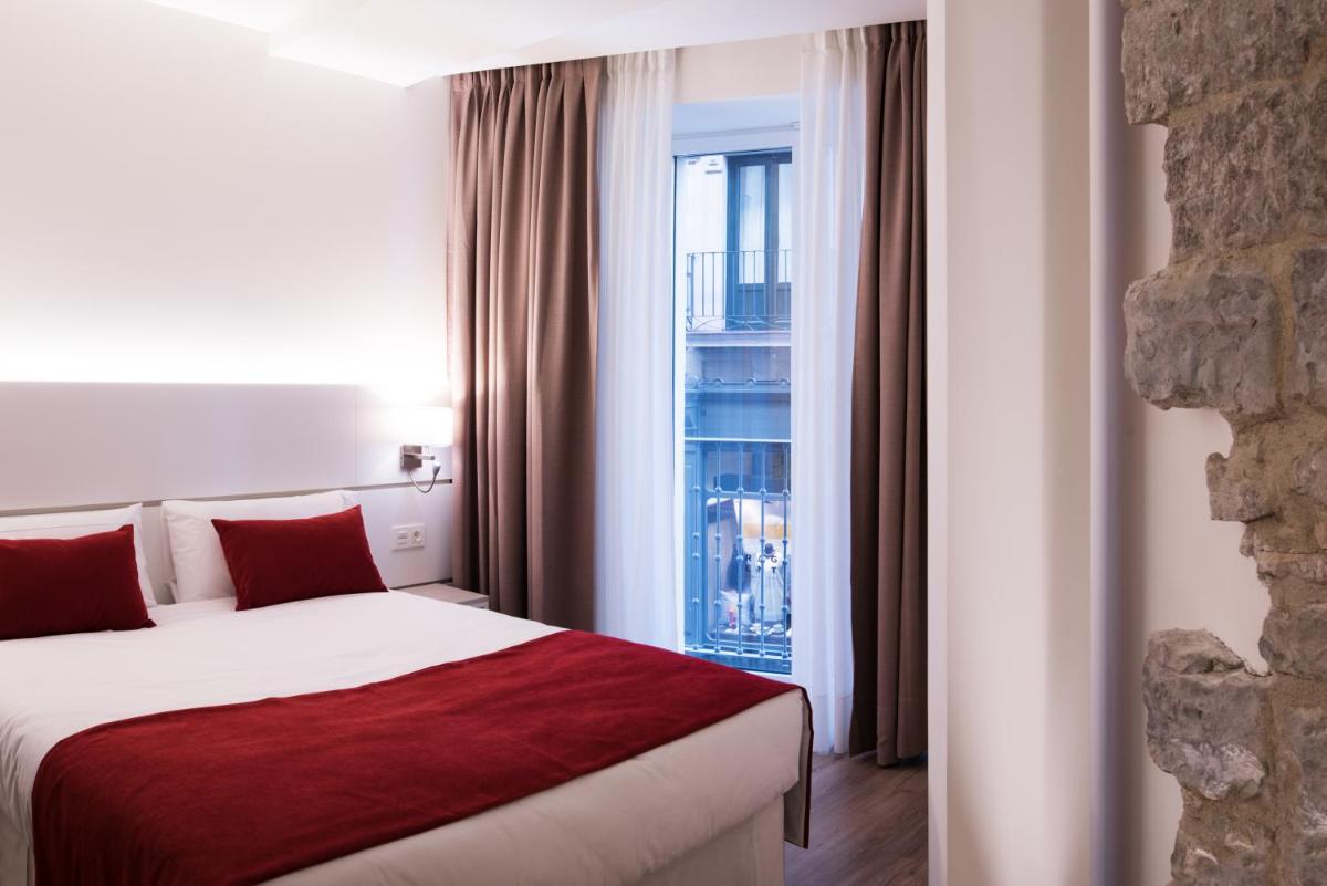 Una habitación de hotel con una cama y una ventana. en Hotel Pompaelo Plaza del Ayuntamiento & Spa, en Pamplona 123 fotos más