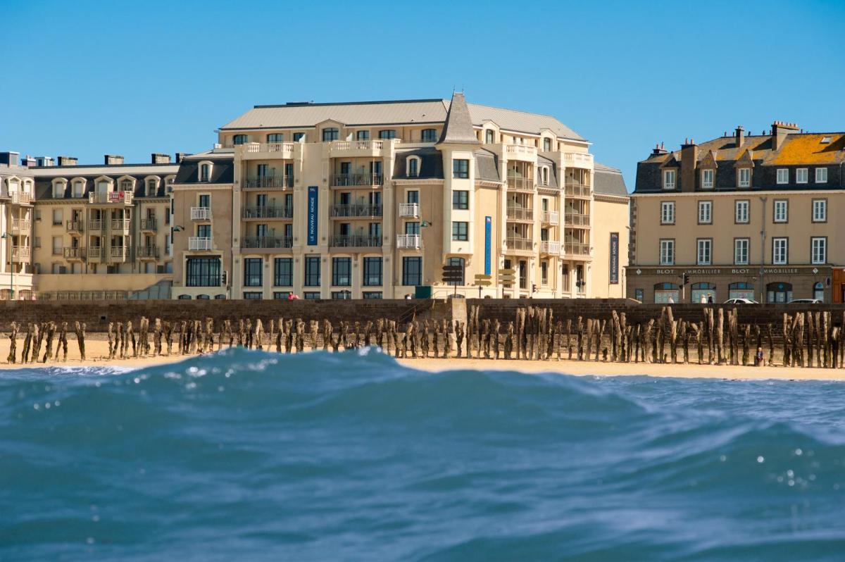 un groupe de bâtiments sur la plage près de l'océan dans l'établissement Hôtel Le Nouveau Monde, à Saint-Malo