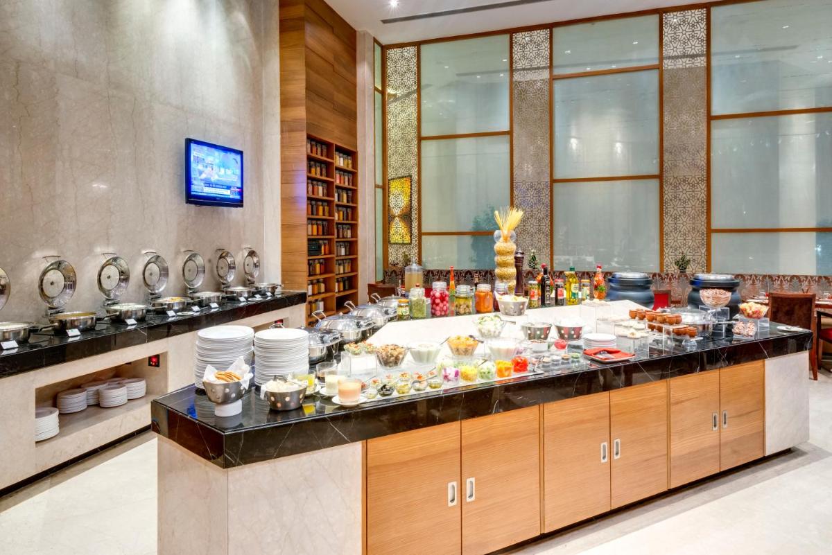 a buffet line with food on it in a restaurant at Pride Plaza Hotel, Kolkata in Kolkata